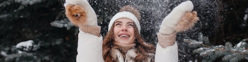 smiling woman playing with snow